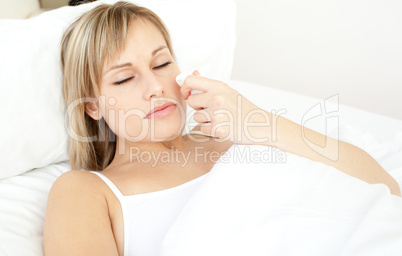 Portrait of a sick beautiful woman lying on a bed