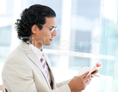 Self-assured businessman reading a newspaper