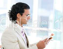 Self-assured businessman reading a newspaper