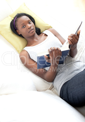 Beautiful woman reading lying on a sofa