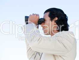 Portrait of a latin business man looking through binoculars