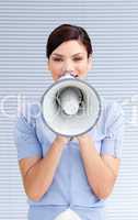 Positive businesswoman yelling through a megaphone