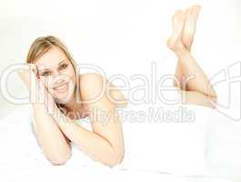 Radiant blond woman lying down on bed