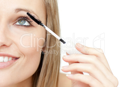 Portrait of a radiant woman putting mascara