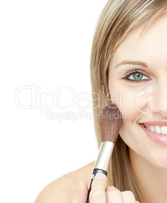 Radiant woman using a powder brush