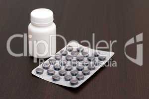 White vial, black pills