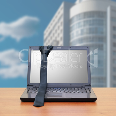 Laptop, tie in the office interior
