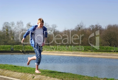Kind rennt am Ufer eines Sees