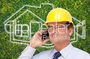Contractor in Hardhat on Cell Phone Over House Icon and Grass