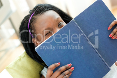 Close-up of a happy woman studying lying on a sofa