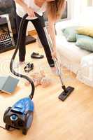 Young woman vacuuming the living-room