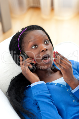 Portrait of a surprised Afro-American woman talking on phone