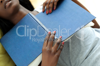 Close-up of a tired woman sleeping while studying