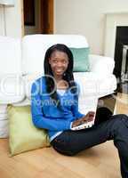 Young woman using a laptop sitting on the floor