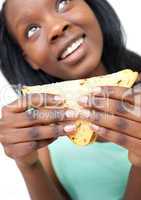 Smiling young woman eating a sandwich
