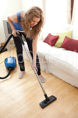 Portrait of a young woman vacuuming