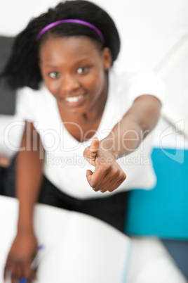 Cheerful teen girl with a thumb up studying