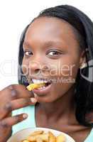 Cheerful young woman eating fries