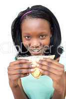 Happy young woman eating a sandwich