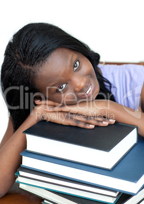 Smiling student leaning on a stack of books
