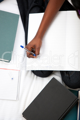 Close-up of a woman studying sitting on her bed