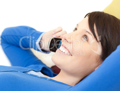 Attractive young woman talking on phone lying on a sofa