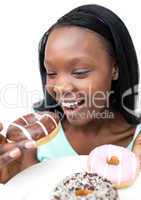 Joyful young woman eating a chocolate donut