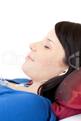 Happy teen girl listening music lying on a sofa