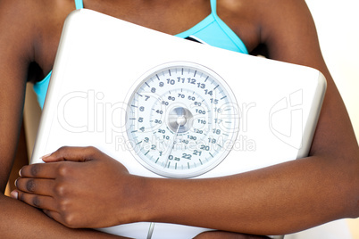 Close-up of a fitness woman with thumb up holding a weight scale