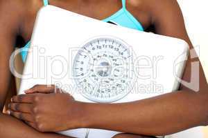 Close-up of a fitness woman with thumb up holding a weight scale