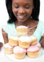 Smiling young woman looking at cakes