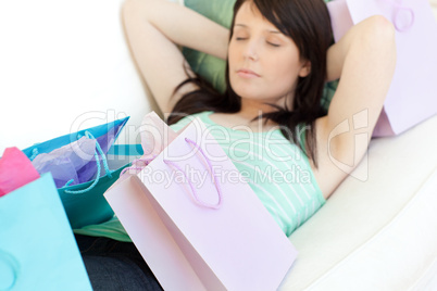 Exhausted young woman relaxing after shopping