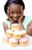Jolly young woman looking at cakes