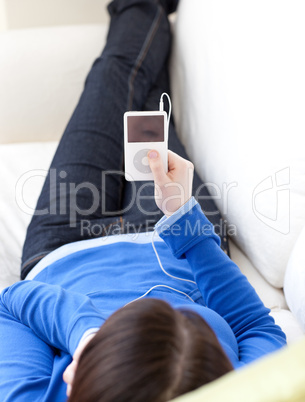 Close-up of a caucasian teen girl listening music lying on a sof