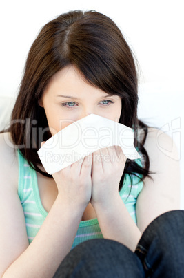 Sick charming woman blowing sitting on a sofa