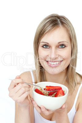 Beautiful woman eating cereals with strawberries