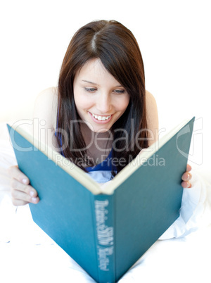 Portrait of a beautiful teen girl studying lying on a bed