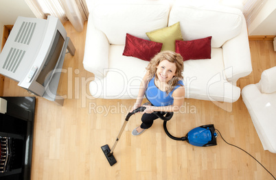 High angle of a happy woman vacuuming