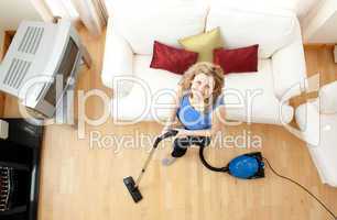 High angle of a happy woman vacuuming