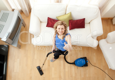 High angle of a cheerful woman vacuuming