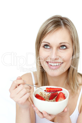 Smiling woman eating cereals with strawberries