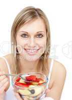 Happy woman eating a fruit salad