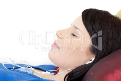 Relaxed teen girl listening music lying on a sofa