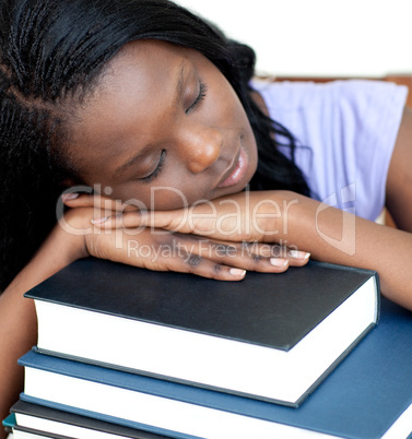 Exhausted student leaning on a stack of books