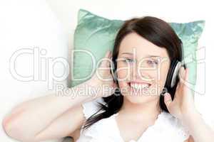 Smiling young woman listening music with headphones