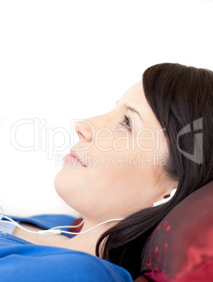 Charming teen girl listening music lying on a sofa