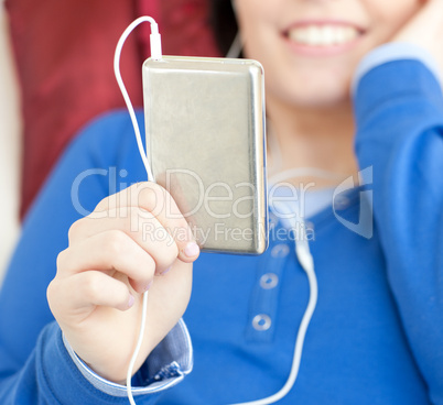 Close-up of a young woman listening music lying on a sofa