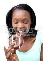 Jolly young woman eating a chocolate donut