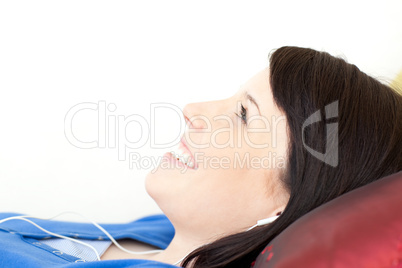 Attractive teen girl listening music lying on a sofa