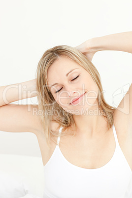 Relaxed woman stretching sitting on her bed